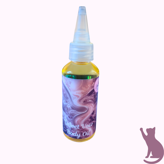 A small bottle of body oil with a pointed applicator cap, filled with yellow oil and featuring a purple marbled label that reads 'Velvet Vow Body Oil'. The bottle is centered on a very pale pink background with a purple cat silhouette in the bottom right corner.